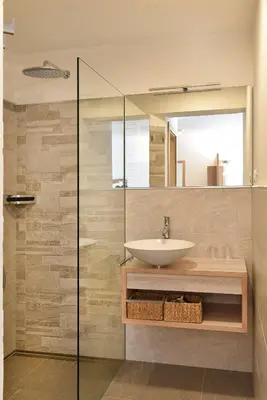 a bathroom with a sink and a glass shower at Haus Rosengarten in Tirolo
