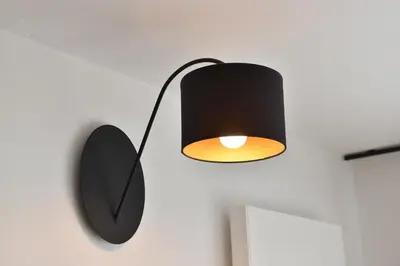 a black lamp and a mirror on a wall at Haus Rosengarten in Tirolo