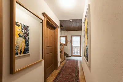 a hallway of a home with paintings on the walls at Ciasa Ilda - Charming house 120 m2 in La Valle
