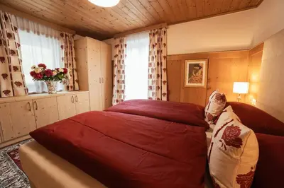 a bedroom with a large red bed in a room at Ciasa Ilda - Charming house 120 m2 in La Valle