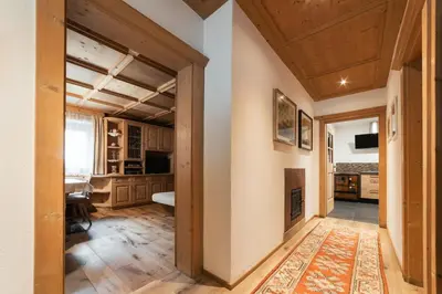 a large room with a fireplace and wooden ceilings at Ciasa Ilda - Charming house 120 m2 in La Valle