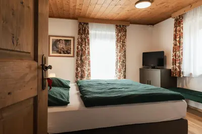 a bedroom with a bed and a window at Ciasa Ilda - Charming house 120 m2 in La Valle