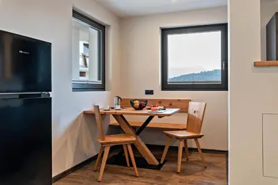 a small kitchen with a table and chairs and a window at Villa Lara Laerche in Castelrotto