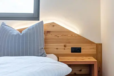 a bedroom with a bed with a wooden headboard at Villa Lara Laerche in Castelrotto