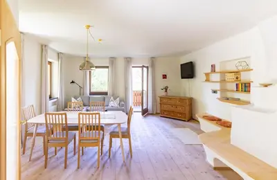 a dining room and living room with a table and chairs at Large apartment with panoramic view in Meluno