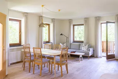 a living room with a table and chairs and a couch at Large apartment with panoramic view in Meluno