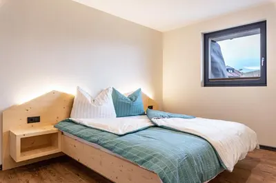 a bedroom with a wooden bed with a window at Villa Lara Fichte in Castelrotto