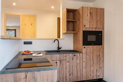a kitchen with wooden cabinets and a sink at Villa Lara Fichte in Castelrotto