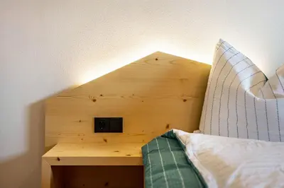 a wooden headboard of a bed with a clock on it at Villa Lara Fichte in Castelrotto