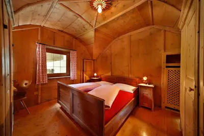 a bedroom with a large bed in a wooden room at Appartments Moarhof in Vols am Schlern