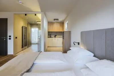a white bedroom with a large bed and a television at Michael Am Waal in Schenna