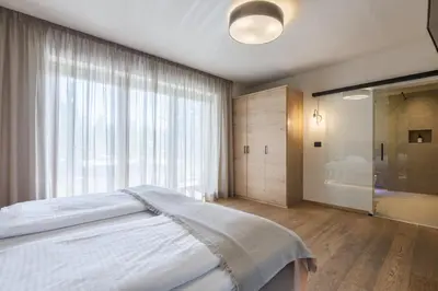 a bedroom with a large bed and a bathroom at Michael Am Waal in Schenna