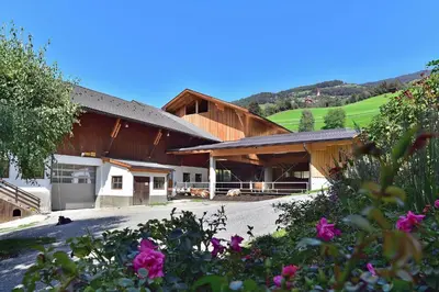 a group of buildings with flowers in the foreground at Putzerhof - Urlaub auf dem Bauernhof in Brixen