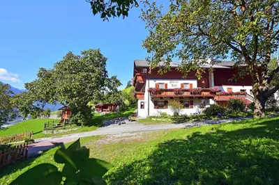 a house on a hill with a green yard at Putzerhof - Urlaub auf dem Bauernhof in Brixen