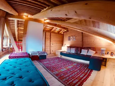 an attic room with a bed and a large rug at Stunning Luxury House in Cortina dʼAmpezzo