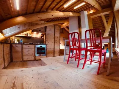 a kitchen with red chairs and a table in a cabin at Stunning Luxury House in Cortina dʼAmpezzo