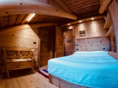 a bedroom with a bed in a wooden room at Stunning Luxury House in Cortina dʼAmpezzo