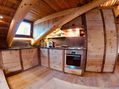 a kitchen in a log cabin with wooden walls at Stunning Luxury House in Cortina dʼAmpezzo