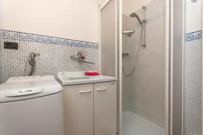 a white bathroom with a sink and a shower at Tabia delle Rose in Piaia
