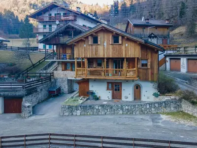 a large wooden house with a balcony on a mountain at Tabia delle Rose in Piaia