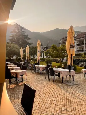 a group of tables and chairs with umbrellas at Goldenhof in Ora/Auer