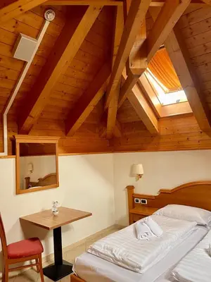 a bedroom with a bed and a table and a window at Goldenhof in Ora/Auer
