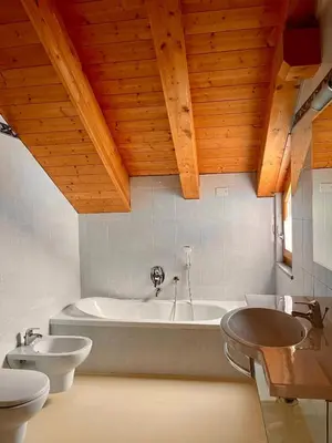 a bathroom with a tub and two toilets and a sink at Goldenhof in Ora/Auer