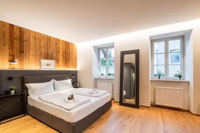 a bedroom with a large bed and two windows at Heart of Bolzano in Bolzano