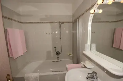 a bathroom with a tub and a sink and a toilet at Hotel Villa Mozart in Pozza di Fassa