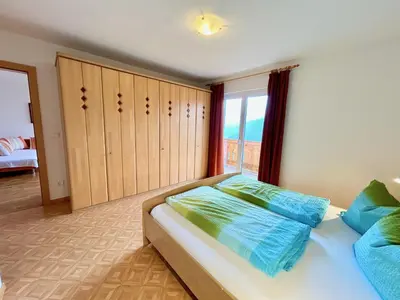 a bedroom with a bed with blue pillows on it at Haslingerhof - Ferienwohnung Ortler in Saltusio