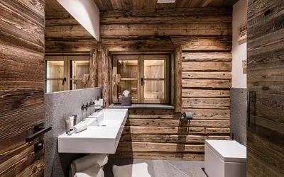 a bathroom with two sinks and wooden walls at La Mendola Alm-Chalet in Mendola