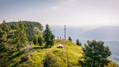 a cross on top of a hill with trees at La Mendola Alm-Chalet in Mendola
