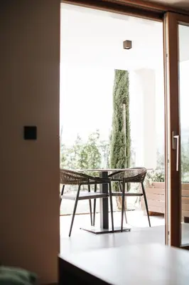 a table and chairs in front of a window at Platterhof in Tirolo