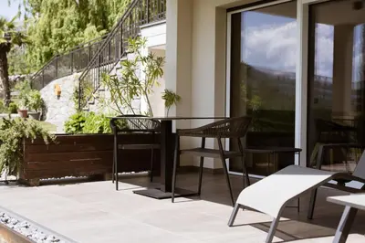 a patio with two chairs and a table and a window at Platterhof in Tirolo