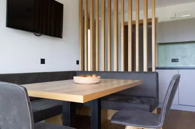 a dining room with a wooden table and chairs at Platterhof in Tirolo