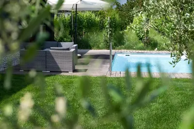 a pool in a yard with a couch next to it at Appartements St Urban in Cornaiano