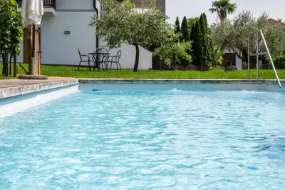 a swimming pool with blue water in a yard at Appartements St Urban in Cornaiano