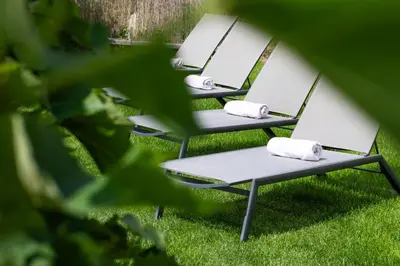 a row of chairs sitting in the grass at Appartements St Urban in Cornaiano