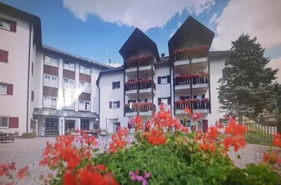 a large building with flowers in front of it at Santa Cristina SudTirol SassLong Flat in Santa Cristina in Val Gardena
