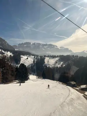 a person skiing down a snow covered slope on a ski lift at Santa Cristina SudTirol SassLong Flat in Santa Cristina in Val Gardena