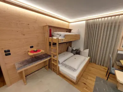 a room with two bunk beds and a table at Dolomiten Home in Villnoss