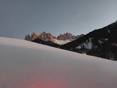 a snow covered hill with a mountain in the background at Dolomiten Home in Villnoss