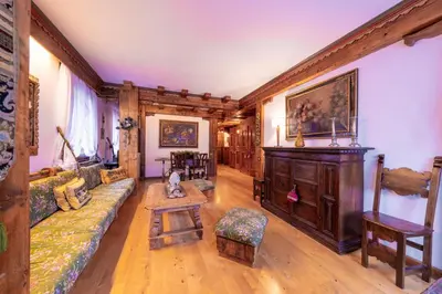 a living room with a couch and a piano at Cortina City Center Alpine Apartment with Private Garage in Cortina dʼAmpezzo