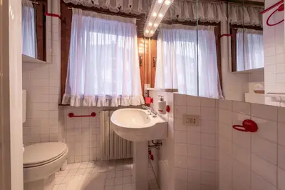 a small bathroom with a sink and a toilet at Cortina City Center Alpine Apartment with Private Garage in Cortina dʼAmpezzo