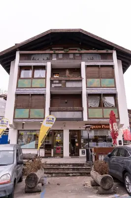 a building with cars parked in front of it at Cortina City Center Alpine Apartment with Private Garage in Cortina dʼAmpezzo
