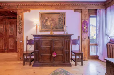 a room with a wooden cabinet with a painting on the wall at Cortina City Center Alpine Apartment with Private Garage in Cortina dʼAmpezzo