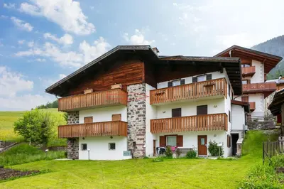 a house with wooden balconies on the side of it at Ciasa Coderoppola in Moena