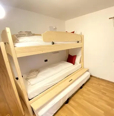 a bedroom with two bunk beds in a room at Ciasa Coderoppola in Moena