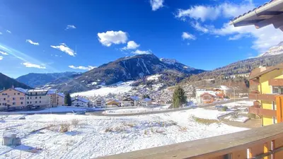 a view of a town in the snow with mountains at Ciasa Coderoppola in Moena