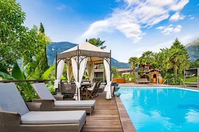 a villa with a swimming pool and a gazebo at Ruster Resort in Lagundo